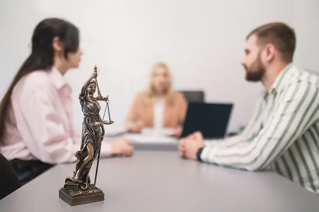Haus verkaufen bei Scheidung – Beratungsgespräch mit Justitia-Figur zur rechtlichen Klärung